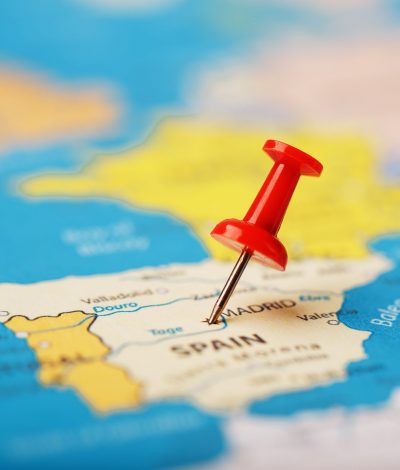 The location of the destination on the map of Spain is indicated by a red pushpin. Spain marked on the map with a red button. Madrid